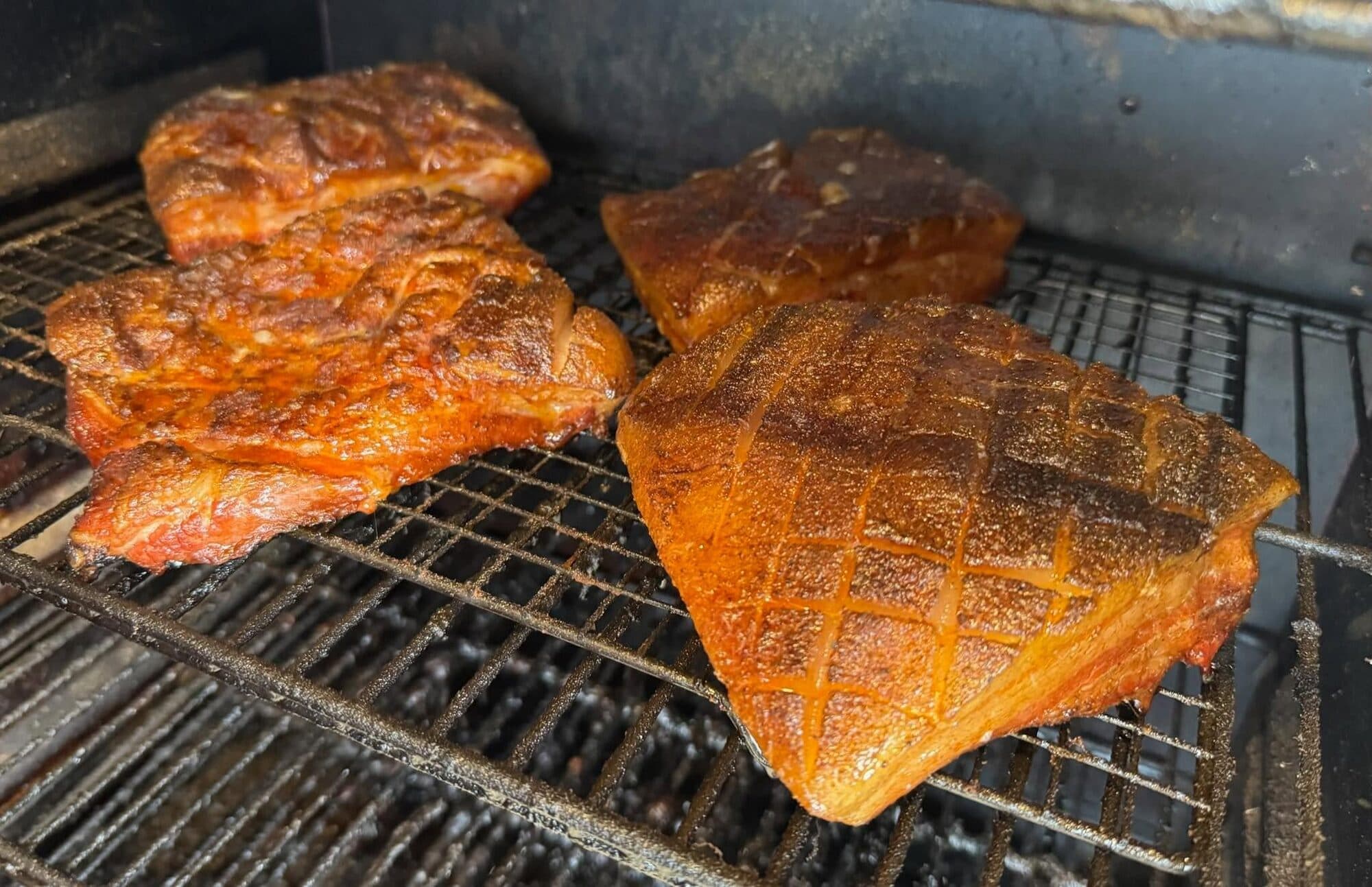 Cajun-rubbed meats smoking low and slow on the grate